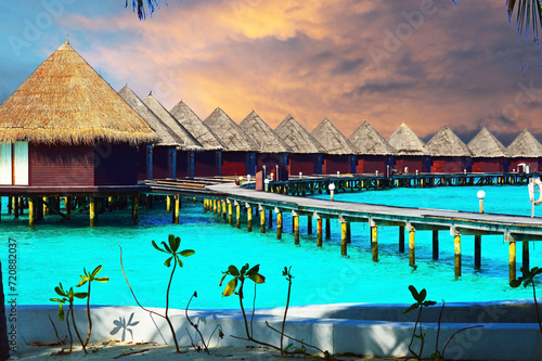 Water villas stand abreast in Maldivian sea under dramatic sky