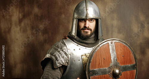 Portrait of a medieval knight in armor. Studio shot over dark background.