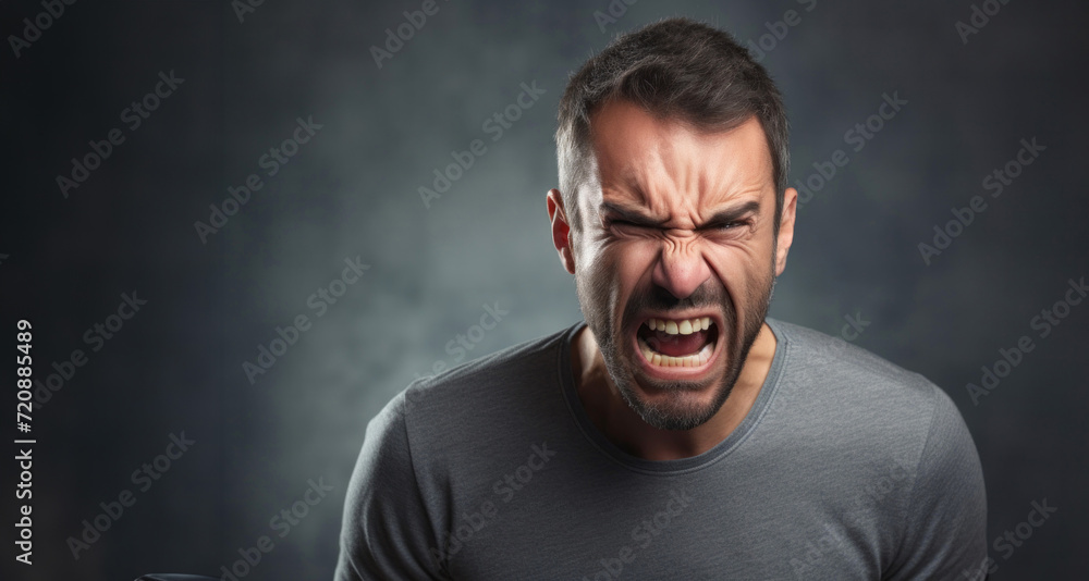 Fototapeta premium Portrait of angry man screaming on dark background. Emotions concept