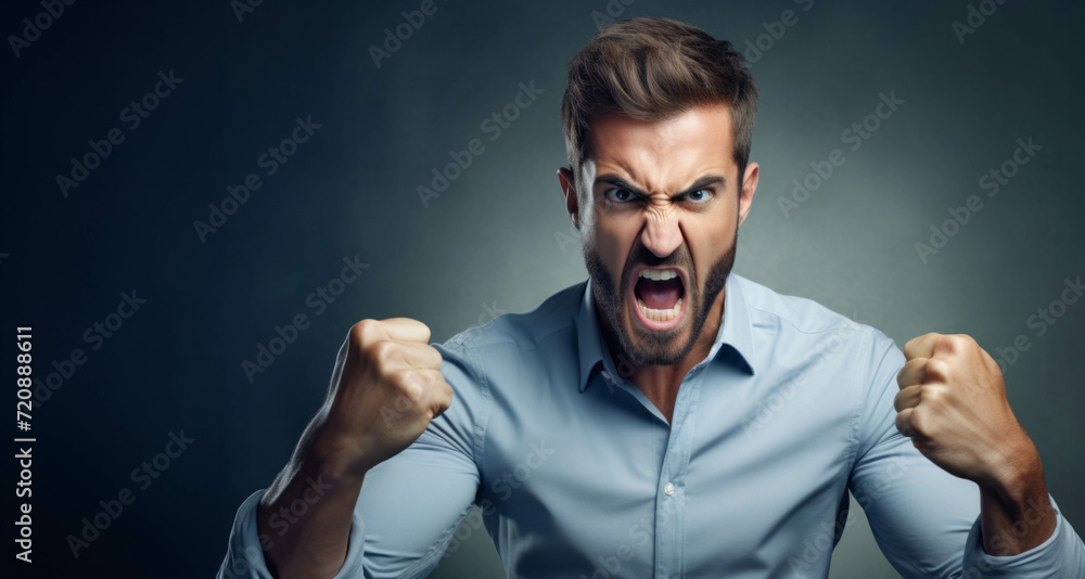 Angry young man screaming and clenching fists over dark background. Angry young man screaming and clenching fists over dark background.