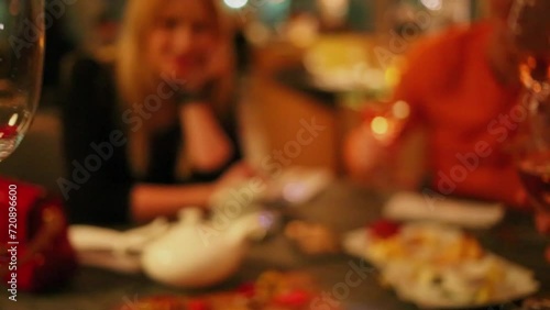 People clinks by four glasses with white vine at restaurant