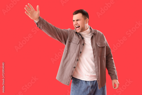 Angry young man shouting on...