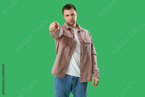 Young man pointing at viewe...