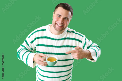 Young man pointing at cup o...