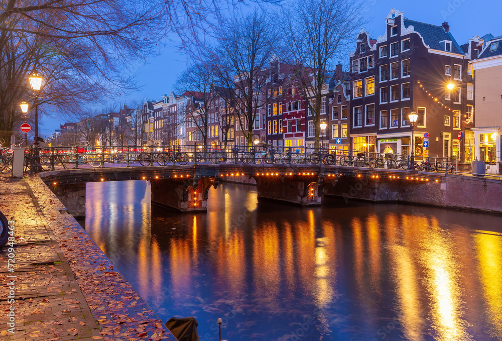 Amsterdam canal Leidsegracht with typical dutch houses and bridge at night, Holland, Netherlands