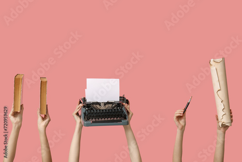 Women with vintage typewriter and books on pink background photo