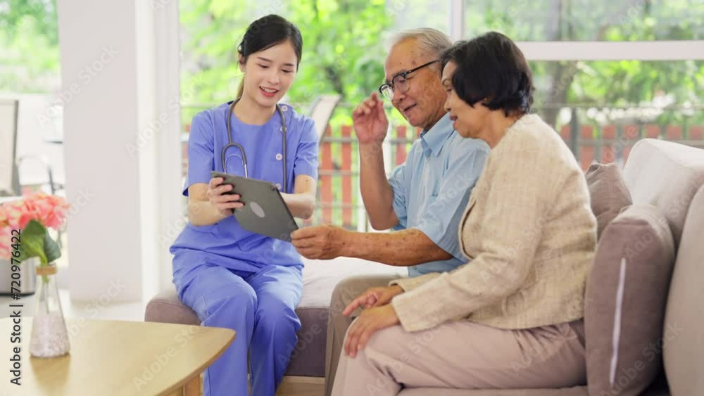 Professional Asian nurse or doctor use tablet to consult and give assistant to couple senior man and woman in living room of clinic or hospital in senior healthcare center. Professional Asian nurse or doctor use tablet to consult and give assistant to couple senior man and woman in living room of clinic or hospital in senior healthcare center.