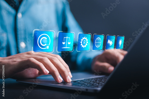 Copyright or patent concept. Businessman use laptop with virtual screen of copyright symbol for author rights and patented intellectual property. copyleft trademark license.