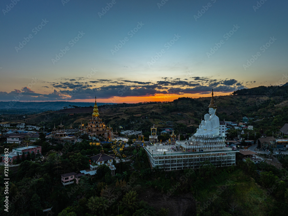 Aerial view amazing Big White Five buddha Statues in sunset. beautiful golden pavilion of Wat Phachonkeaw decorate with jewels and stones on the hill very beautiful and famous landmark in Thailand.