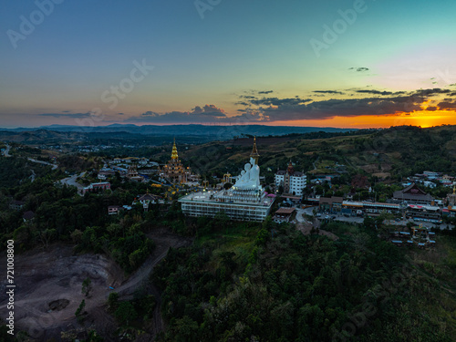 Aerial view amazing Big White Five buddha Statues in sunset. beautiful golden pavilion of Wat Phachonkeaw decorate with jewels and stones on the hill very beautiful and famous landmark in Thailand.