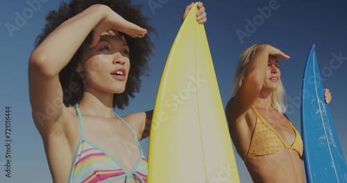 Diverse couple with surfboards at the beach, with copy space