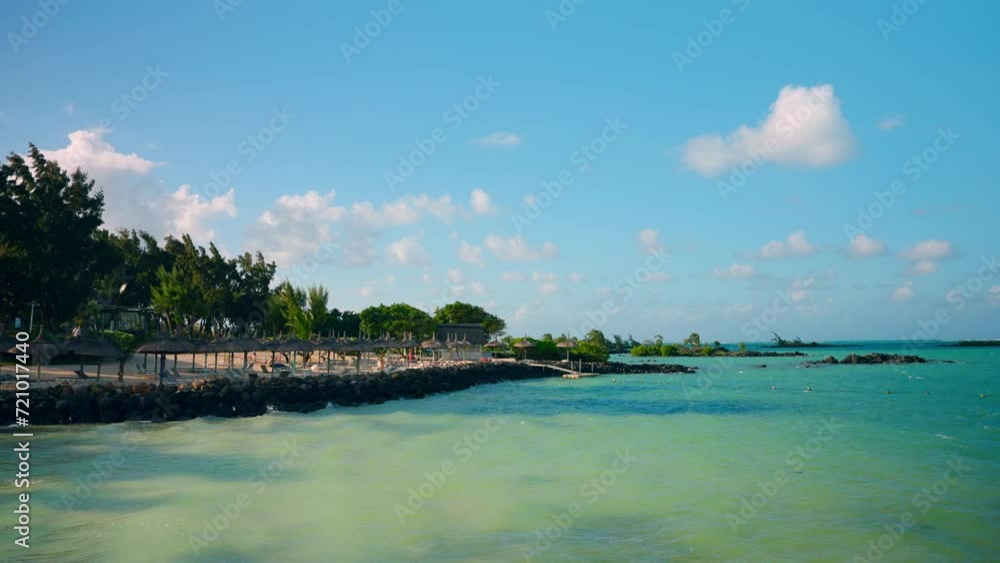 Timelapse of tropical beach resort in the Mauritius. High travel of clouds, turquoise ocean, wooden beach umbrellas. Timelapse of tropical beach resort in the Mauritius. High travel of clouds, turquoise ocean, wooden beach umbrellas.