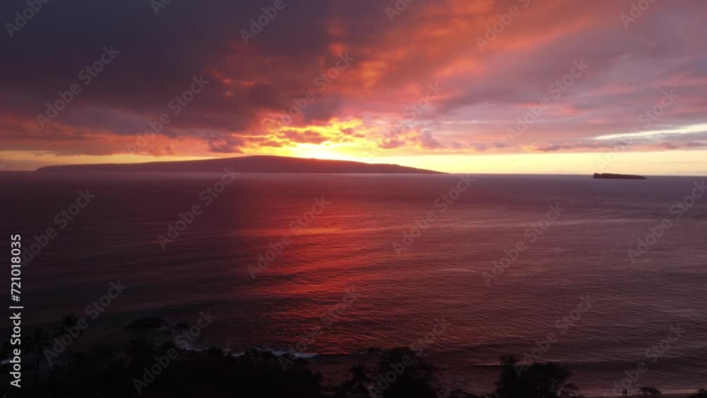 Stunning aerial view of Molokini Crater and the sacred island of Kaho'olawe in the distance during amazing red sunset in Maui, Hawai'i. 4K Stunning aerial view of Molokini Crater and the sacred island of Kaho'olawe in the distance during amazing red sunset in Maui, Hawai'i. 4K