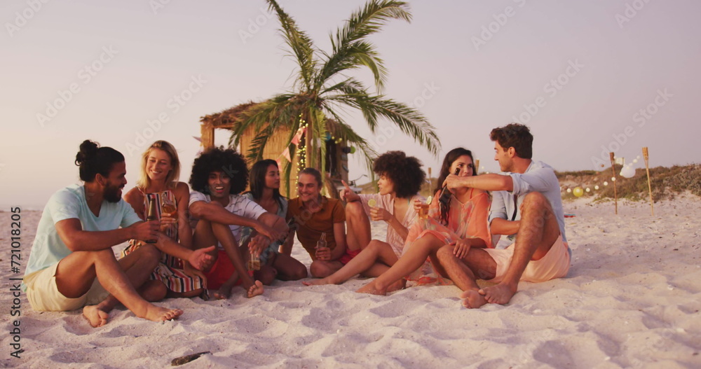 Fototapeta premium Diverse group of friends enjoy a beach sunset, with copy space