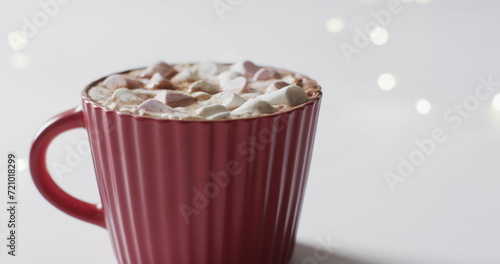 A red mug filled with hot chocolate and marshmallows, with copy space