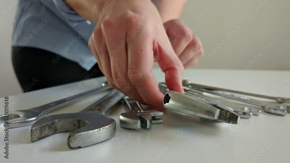 Woman picking up adjustable wrench of multiple spanner tools, close up