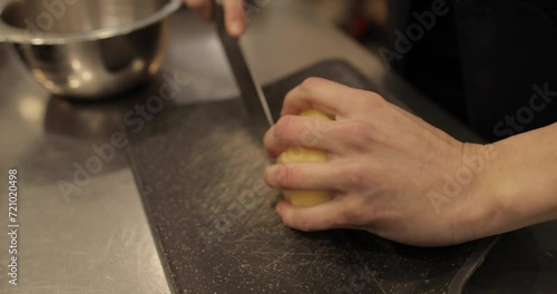 Close-up of female hands slicing apples into cubes for making apple dessert in a professional pastry shop. photo