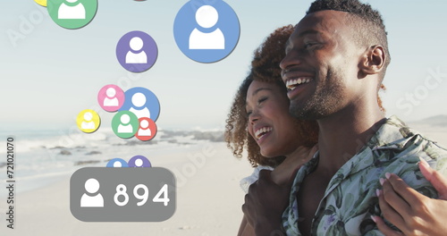 Profile icons with increasing numbers floating against african american couple smiling on the beach