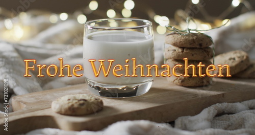 Frohe weihnachten text in orange over christmas cookies and milk with bokeh lights
