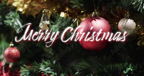 Merry christmas text over decorations hanging on christmas tree © vectorfusionart