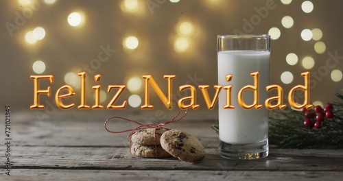 Feliz navidad text in orange over christmas cookies and milk and bokeh lights background