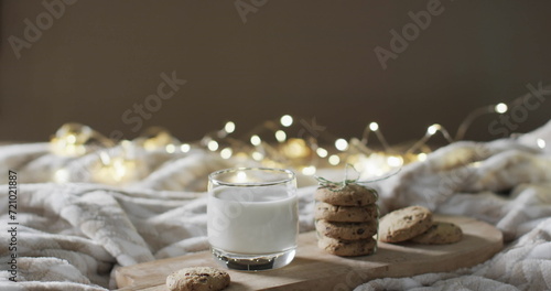 A glass of milk and cookies on a cozy bed setup, with copy space