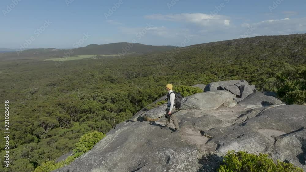 Slow motion shot of a man at a lookout point with camera in hand, ready to film and shoot the scene. Slow motion shot of a man at a lookout point with camera in hand, ready to film and shoot the scene.