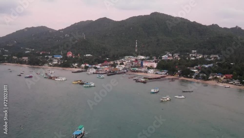 Aerial View Over Koh Tao Pier With Boats Moored In Ocean. Pull Back , Tilt Up Shot photo