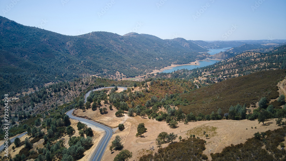 a winding road in front of a valley with lots of trees
