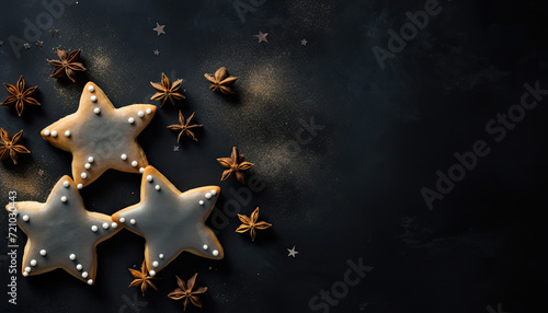 Top view of gingerbread, shortbread or anise cookies with edible gold dust on dark surface with anise stars decoration. Star-shaped Christmas cookies with copy space for text. Generative AI.