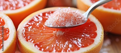 Citrus dessert: Red grapefruit with sugar in a tea-spoon.
