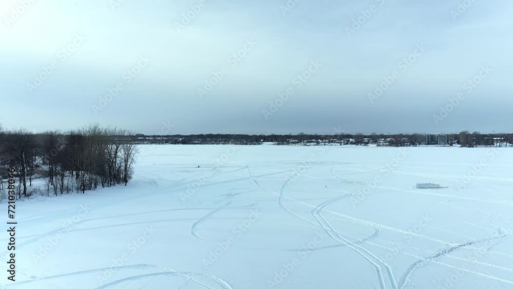 Aerial drone view coming down overt he frozen river showing a snow fort made by kids and round tracks in the snow at Berge-des-goelands in Laval-Ouest-24fps Aerial drone view coming down overt he frozen river showing a snow fort made by kids and round tracks in the snow at Berge-des-goelands in Laval-Ouest-24fps