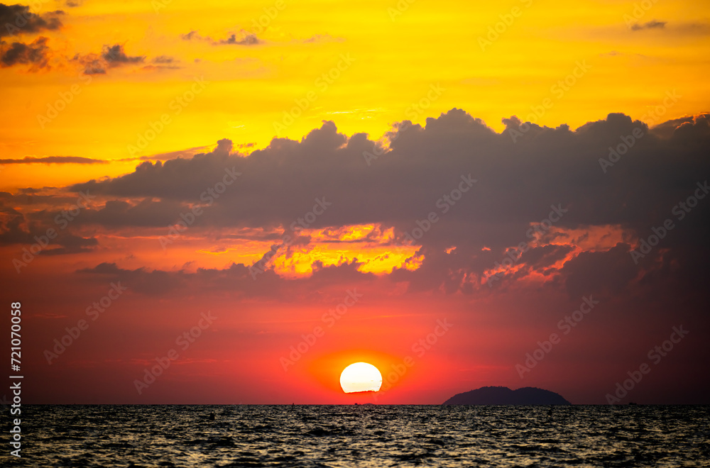fiery sunset over ocean, with vibrant shades of orange and red painting sky. sun sets dramatically, casting warm glow on dark waters below, creating breathtaking reflection of nature's stunning canvas