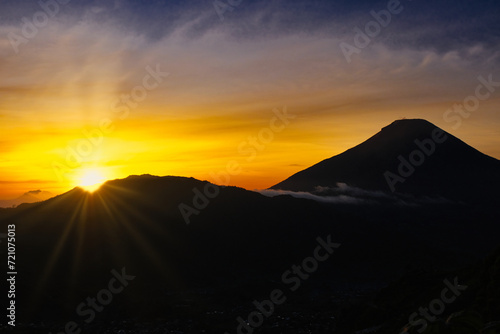 Golden sunrise from behind Sindoro and Sumbing mountains in Central Java  Indonesia