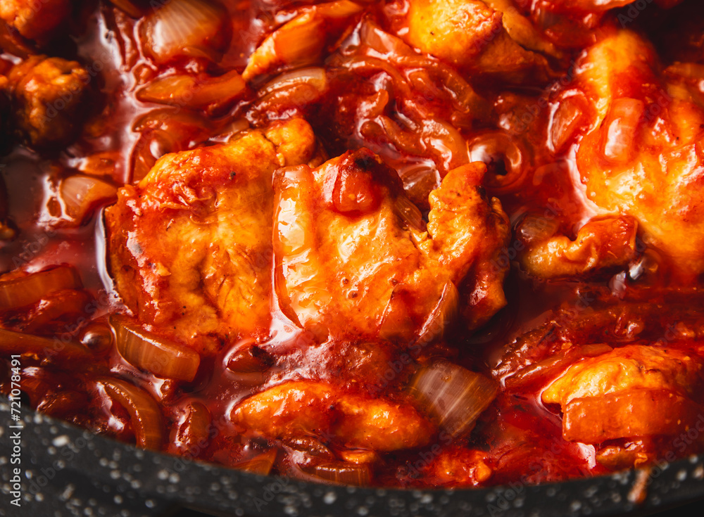 Chicken meat is stewed in tomato in a frying pan Chicken meat is stewed in tomato in a frying pan