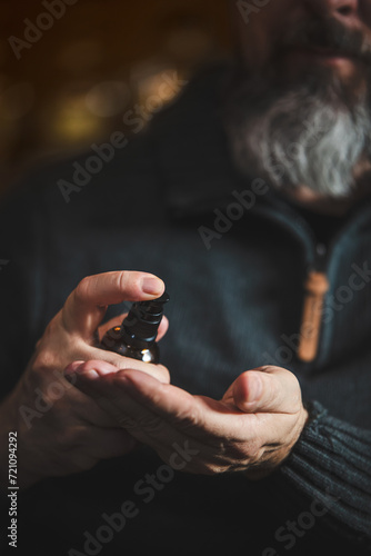 Long bearded man holding a beard oil or serum, men hygiene and lifestyle © M.Dörr & M.Frommherz