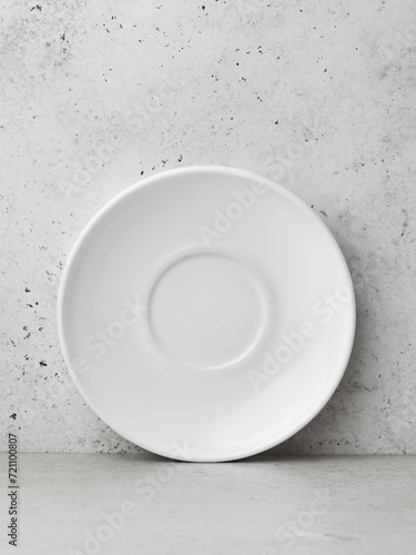 White saucer standing vertically on an abstract background, template for designer