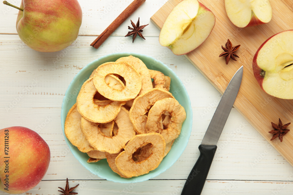 Dried apple chips with cinnamon and star anise with fresh apple. Homemade dried organic apple sliced on white wooden background.