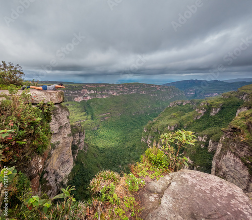 Daredevil Posing as Superman on a Cliff Edge with Forest View