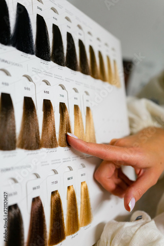 
A folder with hair color samples, a hairdresser working on a hairstyle. Beauty, hair salon concept