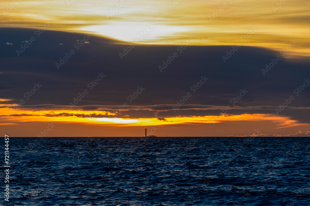 Obraz premium Phare à l'horizon au coucher du soleil