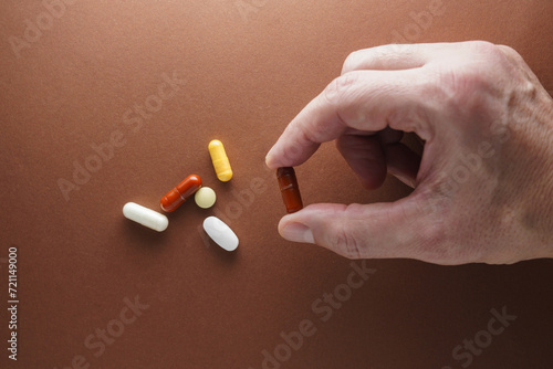 Tabletki na dłoni, ręka trzymająca pigułkę
