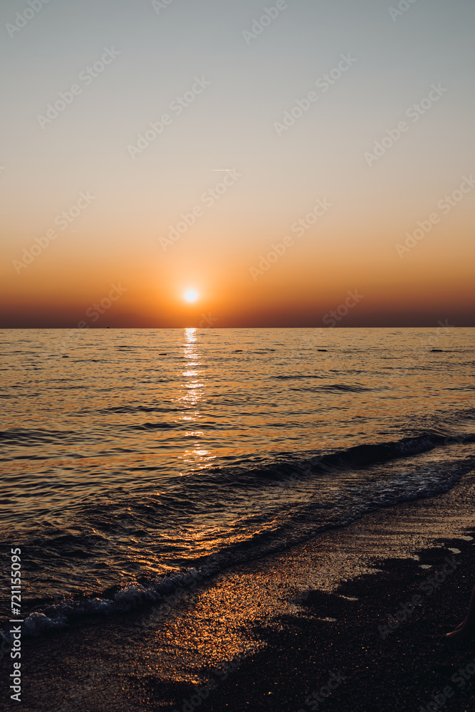 beautiful evening landscape on the sea. sunset of the setting sun. the sun disappeared behind the horizon of the sea. vertical photo of a sea sunset