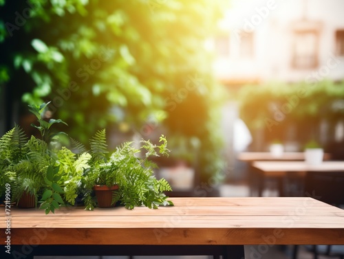 Modern cozy outdoor restaurant with green plants, blurred background with wooden table for product and text placement
