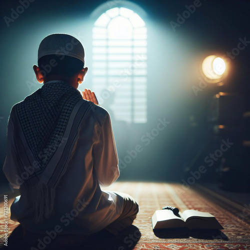 Religious Muslim boy praying with the light in the dark room 
