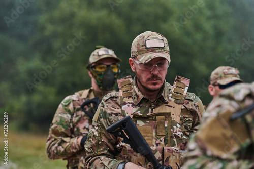 An elite military unit, led by a major, confidently parades through dense forest, showcasing precision, discipline, and readiness for high-risk operations