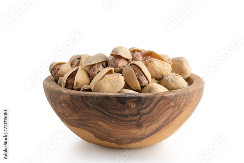 salted pistachios in wood bowl isolated on white background