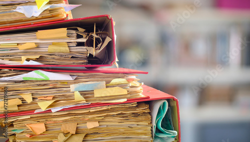 messy file folders,red tape, bureaucracy,aministration,business concept,isolated on blurred office bookshelf backgound