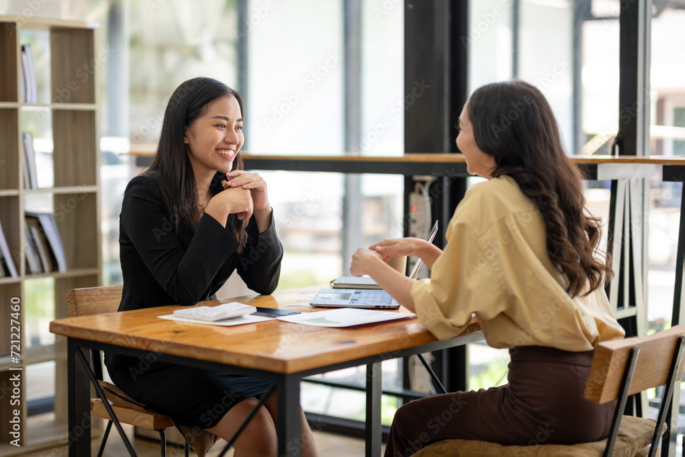 Two Asian businesswomen discuss financial management planning. Analyze new startup project ideas. Share an opinion Two Asian businesswomen discuss financial management planning. Analyze new startup project ideas. Share an opinion