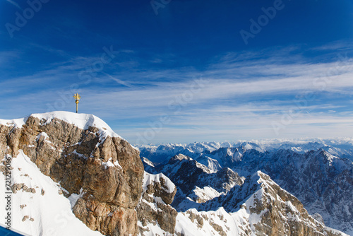 A widescreen panorama of the Zugspitze with summit cross - snowy landscape